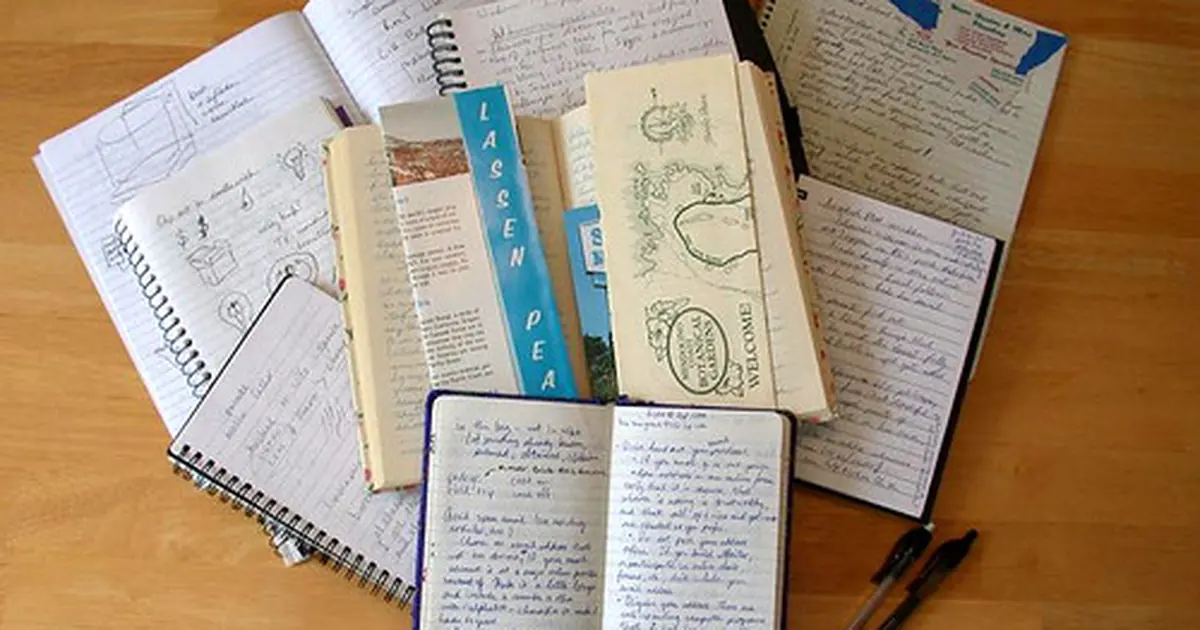 Open notebooks and journals spread on a desk