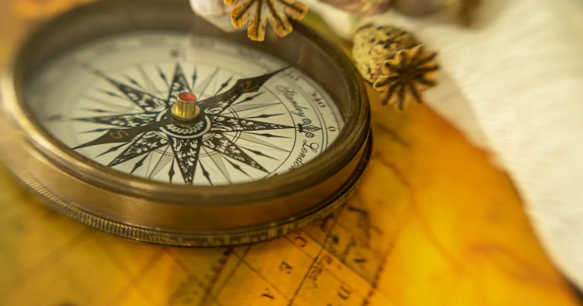 A brass compass resting on a map